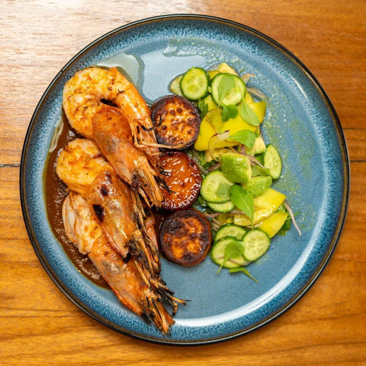 Grilled jumbo prawns with caramelised sweet plantain and a cucumber, avocado and tropical-fruit salad