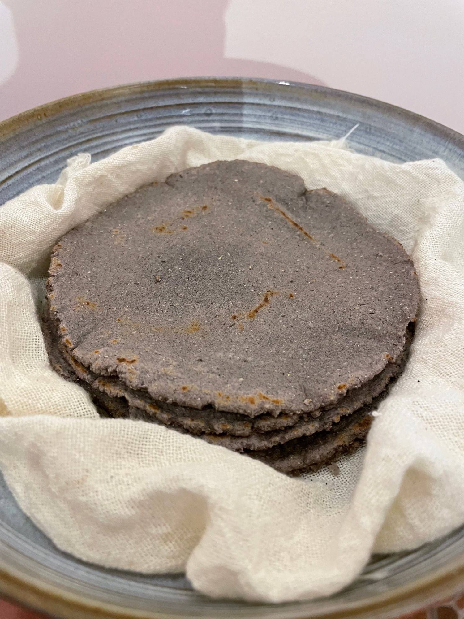 Homemade blue corn tortillas wrapped in a cotton cloth