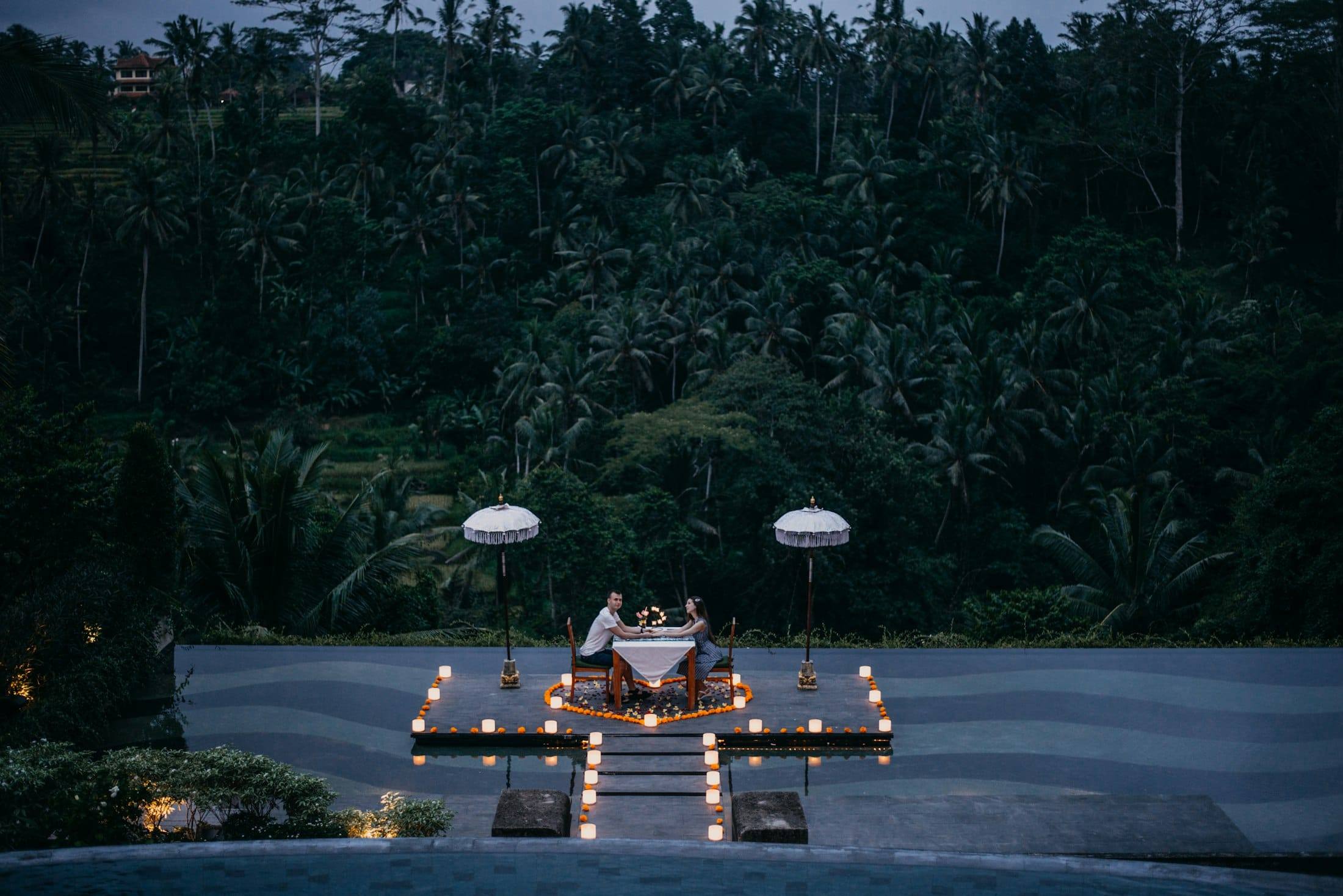 Candlelit dinner for two on a terrace facing the jungle at dusk